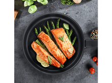 Charger l'image dans la galerie, Une poêle avec du saumon cuit, des asperges et des tranches de citron vert. La poêle est sur une surface sombre.