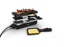 Charger l'image dans la galerie, Grill à raclette avec de la nourriture dessus, et du fromage et des aliments cuits dans des poêles sur le comptoir.