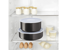 Charger l'image dans la galerie, À l'intérieur d'un réfrigérateur, deux bols noirs avec couvercles blancs, bocaux et œufs, avec des oignons en bas.