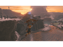 Charger l'image dans la galerie, Un personnage avec un parachute planant au-dessus d'un canyon au coucher du soleil dans un jeu.