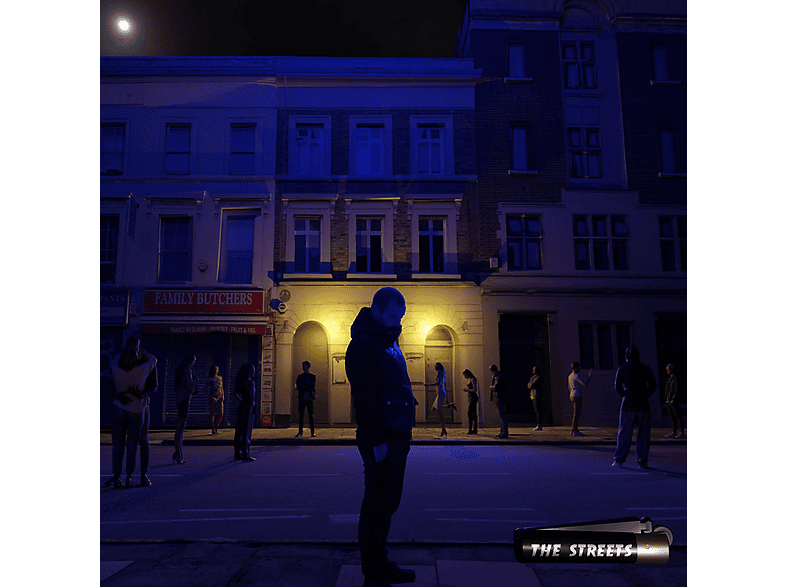Scène de nuit avec des bâtiments et des gens. Un homme au premier plan. Panneau 'The Streets'.
