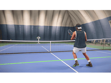 Charger l'image dans la galerie, Un joueur de tennis en short et gilet sur un court bleu, jouant au tennis. Filet au milieu.