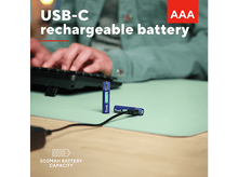 Charger l'image dans la galerie, Piles rechargeables AAA, une en cours d'utilisation, sur un tapis vert avec clavier et mains.