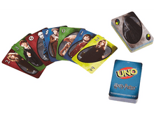 Charger l'image dans la galerie, Jeu de cartes UNO Harry Potter avec cartes étalées sur une surface blanche.