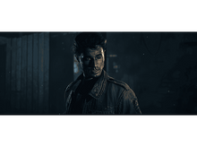 Charger l'image dans la galerie, Un homme avec une expression sérieuse. Il porte une veste et se trouve dans une pièce sombre.