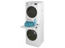 Charger l'image dans la galerie, Lave-linge et sèche-linge empilés blancs. Serviettes et lessive sur le plateau latéral.