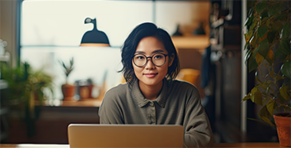 jeune femme avec des lunettes travaillant sur son ordinateur portable.