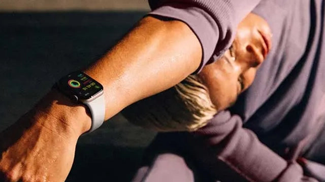 Un homme faisant des étirements avec une Apple Watch au poignet.
