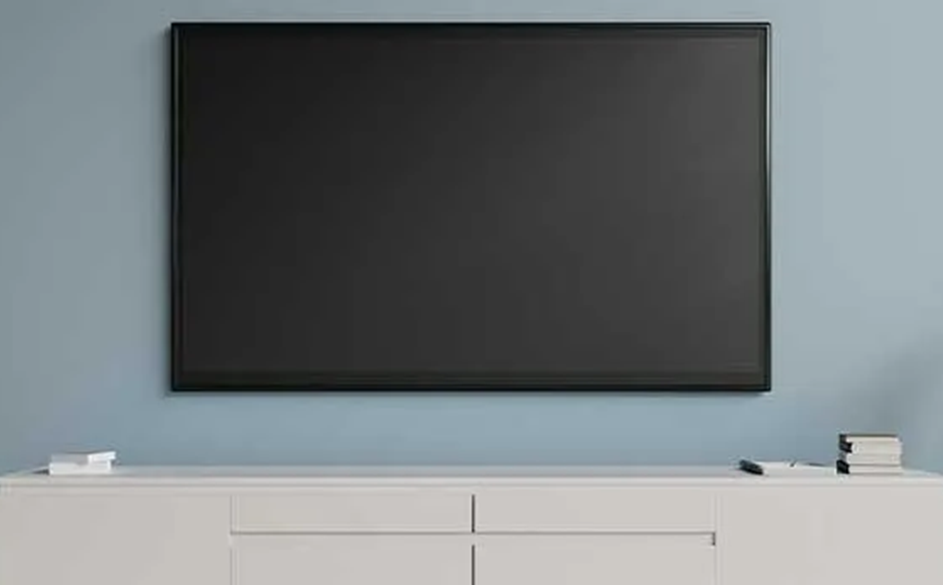 Un écran de tv éteint fixé à un mur bleu dans un décor minimaliste.
