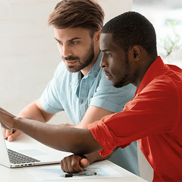 Deux personnes travaillent sur un PC portable.