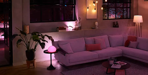 Une pièce de vie avec un grand canapé et de nombreux éclairages connectés Philips Hue.