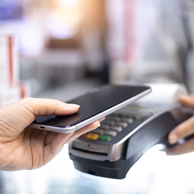 Une personne paye un achat avec son smartphone.
