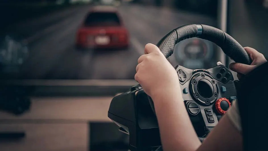 Un enfant jouant à un jeu de course avec un volant gaming devant un écran affichant une voiture rouge.