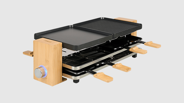 Une raclette électrique avec double plaque, poêlons et finitions en bois.