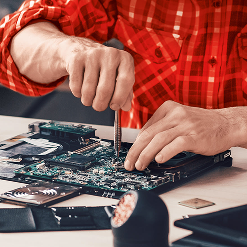 Une personne répare la carte mère d'un PC portable.