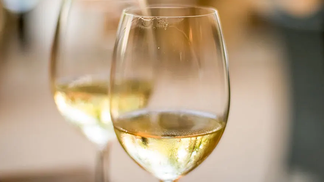 Deux verres de vin blanc à moitié remplis.