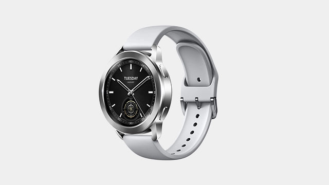 Une montre connectée Xiaomi argentée avec bracelet en silicone gris et écran affichant un cadran noir analogique.