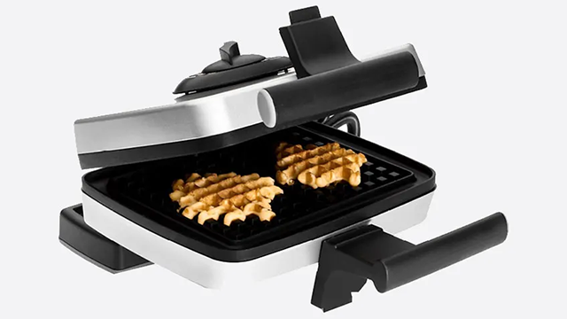 Un gaufrier gris entrouvert avec deux gaufres en cuisson.