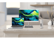 Charger l&#39;image dans la galerie, Un bureau avec un ordinateur portable, un moniteur et un petit appareil blanc. Le moniteur affiche un fond coloré.
