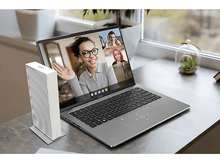 Charger l&#39;image dans la galerie, Un ordinateur portable sur une table avec un appel vidéo à l&#39;écran, un appareil blanc à côté.
