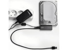 Charger l&#39;image dans la galerie, Adaptateur secteur avec câble connecté à un disque dur et une prise de courant. L&#39;installation est sur une surface blanche.
