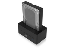 Charger l&#39;image dans la galerie, Un disque dur noir est inséré dans une station d&#39;accueil noire avec une lumière bleue.
