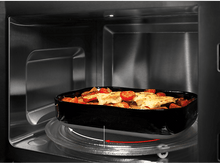 Charger l&#39;image dans la galerie, Nourriture dans un plat noir tournant à l&#39;intérieur d&#39;un four à micro-ondes.
