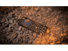 Charger l&#39;image dans la galerie, Téléphone noir sur rochers, effet éclaboussures, écran allumé.
