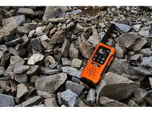 Charger l&#39;image dans la galerie, Un talkie-walkie orange sur un tas de pierres. Il a un écran affichant des chiffres.
