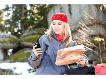 Charger l&#39;image dans la galerie, Femme dans la nature tenant une carte et une radio. Elle porte un bandana rouge, des arbres verts et des rochers.
