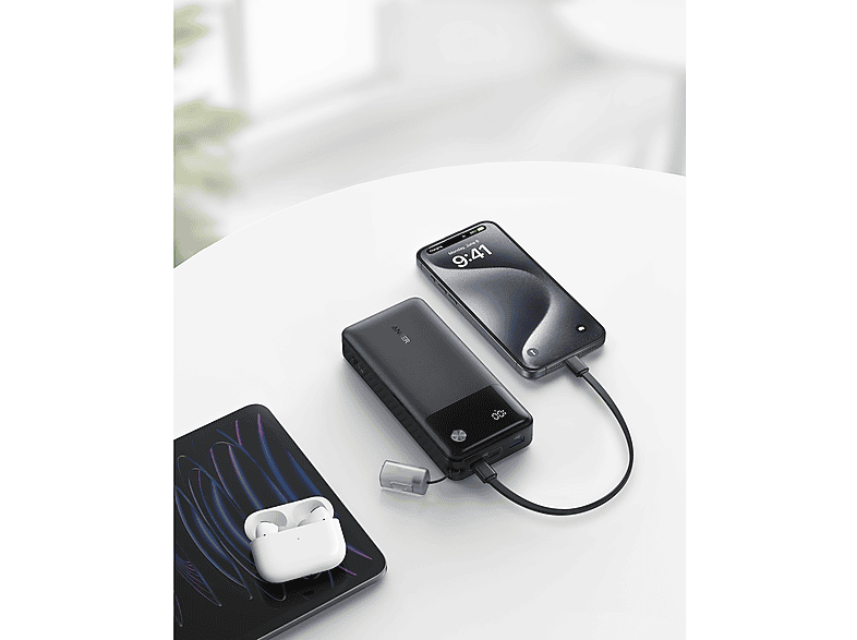 Appareils en charge sur une surface blanche: téléphone, batterie externe et étui écouteurs.