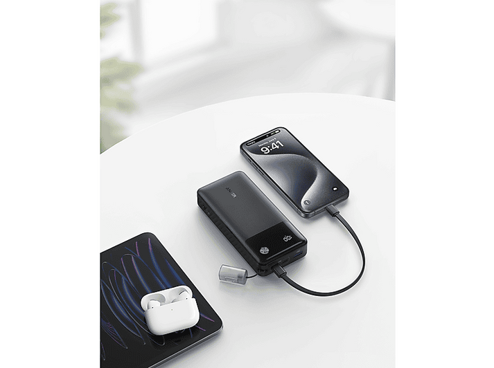 Appareils en charge sur une surface blanche: téléphone, batterie externe et étui écouteurs.