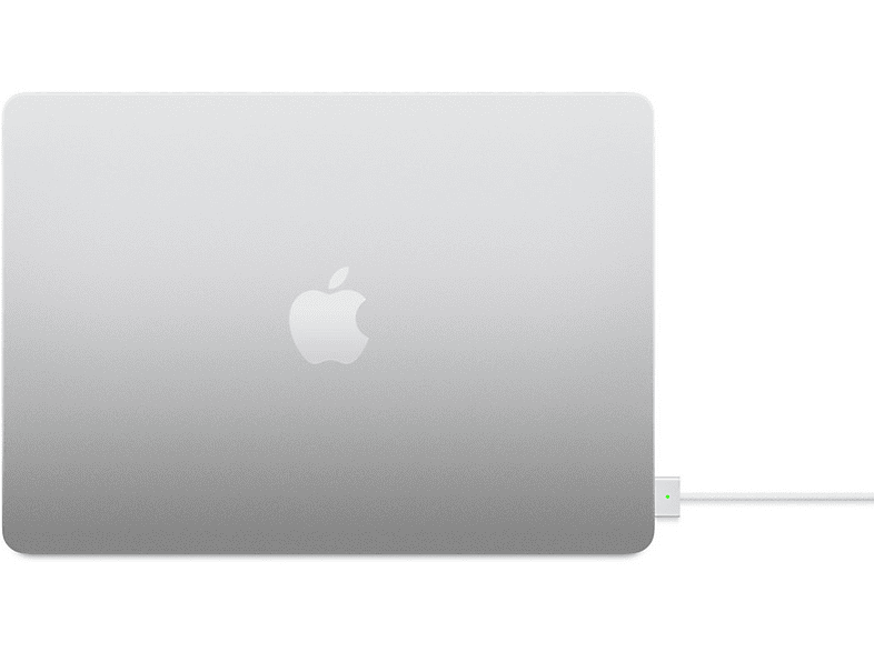 Ordinateur portable argenté, logo Apple. Câble de charge blanc branché, lumière verte.