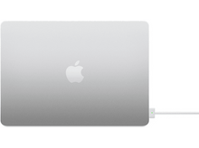 Charger l&#39;image dans la galerie, Ordinateur portable argenté, logo Apple. Câble de charge blanc branché, lumière verte.
