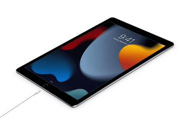 Tablette avec un câble de chargement, montrant un fond d'écran coloré.