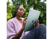 Charger l&#39;image dans la galerie, Une femme tient un iPad Air bleu-vert, avec un crayon blanc, dans un jardin.
