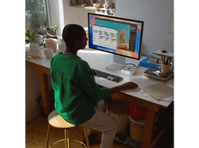 Charger l&#39;image dans la galerie, Personne utilisant un ordinateur avec un moniteur sur un bureau. Le moniteur est argenté.
