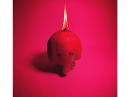 Une bougie en forme de crâne en rouge avec des larmes. La flamme est allumée.