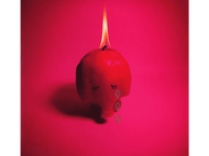 Une bougie en forme de crâne en rouge avec des larmes. La flamme est allumée.