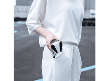 Charger l&#39;image dans la galerie, Une personne tient un petit drone blanc dans sa poche. Le drone a des hélices noires.
