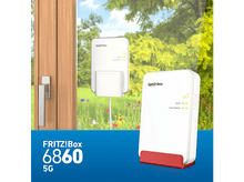 Charger l&#39;image dans la galerie, Deux appareils FRITZ!Box blancs. Un sur un support rouge. Le fond montre une fenêtre avec un jardin vert.
