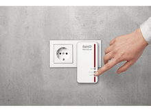 Charger l&#39;image dans la galerie, Une main touche un adaptateur CPL blanc branché sur une prise murale sur un mur gris.
