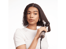 Charger l&#39;image dans la galerie, Une femme se coiffe avec un styler capillaire.
