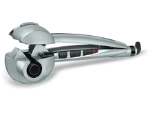 Charger l&#39;image dans la galerie, Fer à boucler Babyliss argenté. Il a une poignée noire et des boutons de commande. La chambre de bouclage est visible.
