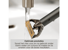 Charger l&#39;image dans la galerie, Gros plan d&#39;un rasoir rincé sous l&#39;eau. Le rasoir est doré et noir. L&#39;eau coule du robinet sur le rasoir.
