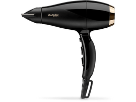 Un sèche-cheveux Babyliss noir et doré, gros plan sur fond noir.