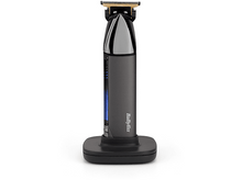 Charger l&#39;image dans la galerie, Une tondeuse à cheveux noire et grise sur sa base de charge, avec un écran LED bleu.
