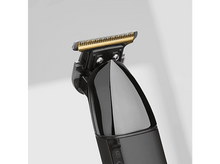 Charger l&#39;image dans la galerie, Gros plan d&#39;une tondeuse à cheveux noire montrant les lames dorées et argentées.
