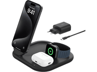 Station de charge noire avec un téléphone, des écouteurs et une montre en charge. Fond blanc.