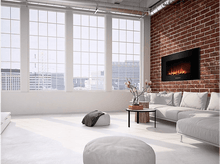 Charger l&#39;image dans la galerie, Un salon moderne avec des murs blancs, un mur d&#39;accent en briques et de grandes fenêtres. Une cheminée est installée.
